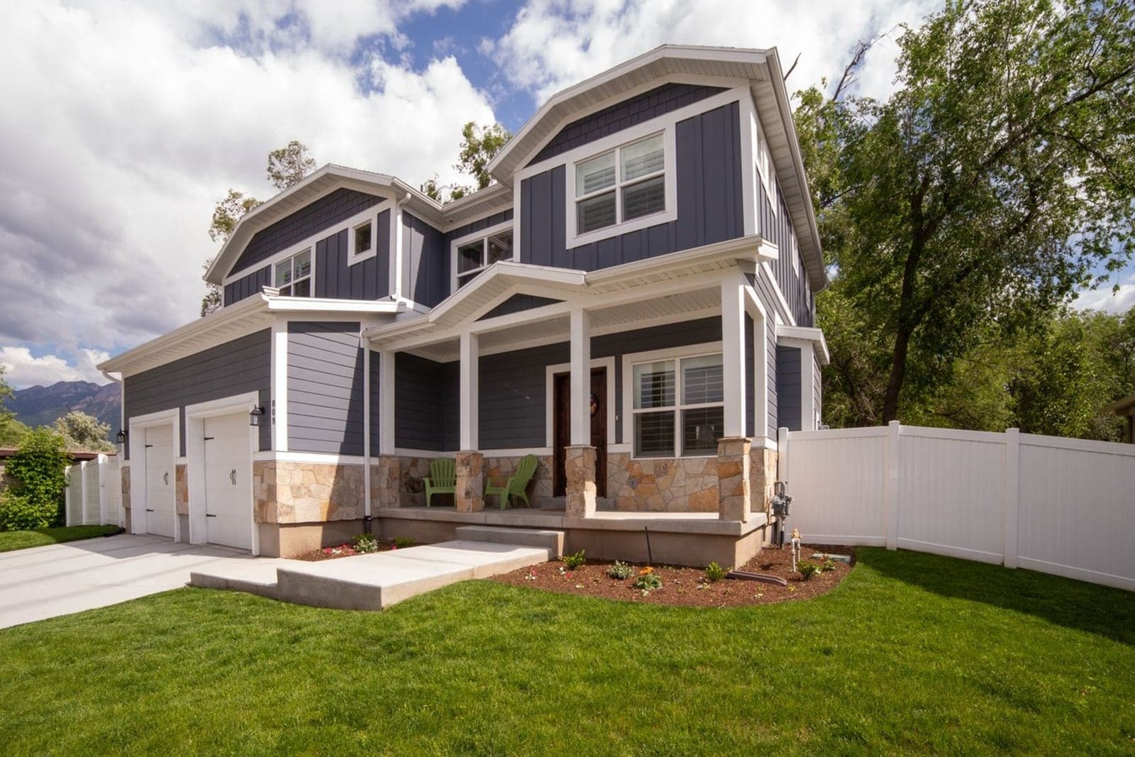 A navy craftsman two-story home with a front porch, undecorated